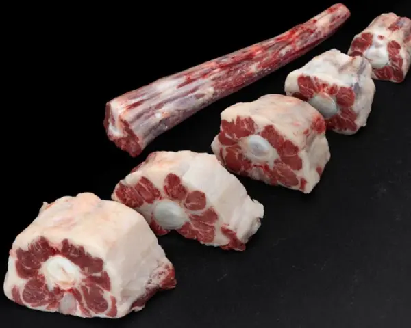 Trozo largo de carne de ternera para guisar y varias porciones cortadas en rodajas, listas para un estofado delicioso.