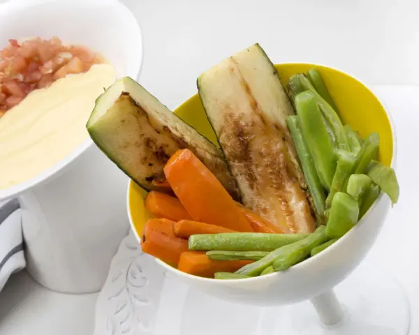 Deliciosas verduras a la plancha: calabacín, zanahoria y judías verdes, servidas con una salsa cremosa y pico de gallo.