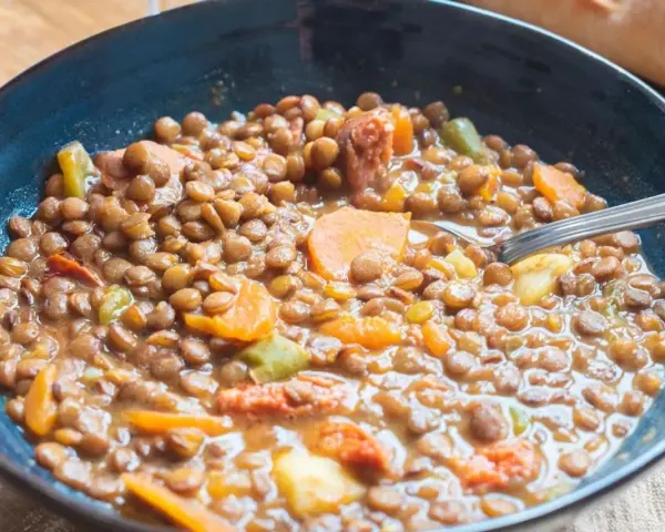 Un plato humeante de lentejas con zanahoria y chorizo, perfecto para una receta casera.