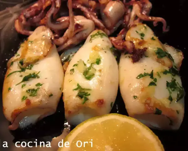 Calamares a la plancha, tiernos y dorados, con perejil fresco y un toque de limón. ¡Un manjar para disfrutar!