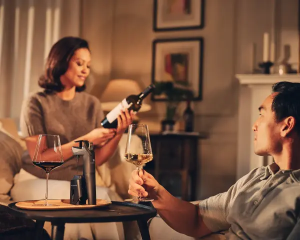 Pareja disfrutando de una copa de vino tinto y blanco. Beber vino es bueno para relajarse y compartir momentos.