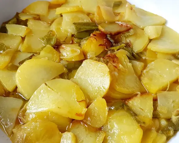 Patatas a lo pobre, un plato sencillo y delicioso, con patatas cortadas finas y tiernas, cocinadas con cebolla y pimientos verdes.