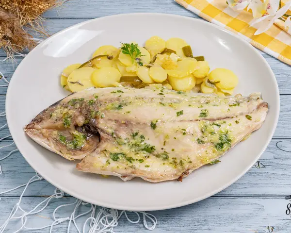 Dorada al horno con patatas y perejil, un plato principal delicioso y saludable.