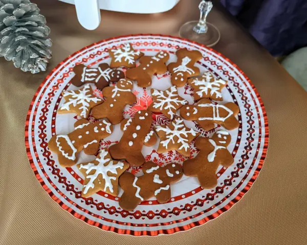 Plato con galletas de jengibre decoradas con glaseado blanco, con formas de hombrecitos, estrellas y copos de nieve. ¡Perfectas para la temporada navideña!