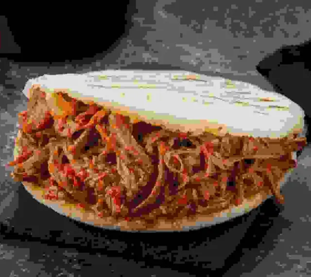 Arepa rellena de jugosa carne mechada, un clásico venezolano listo para disfrutar.