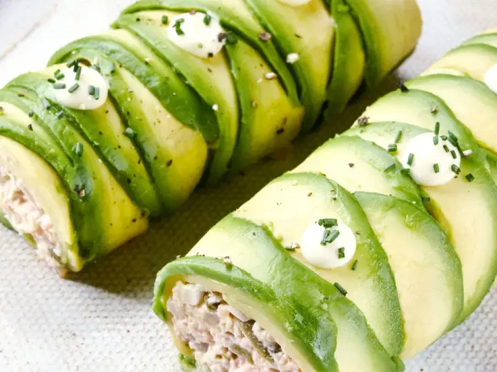 Rollos de aguacate rellenos, perfectos para recetas con aguacate. Decorados con puntos de crema y cebollino.