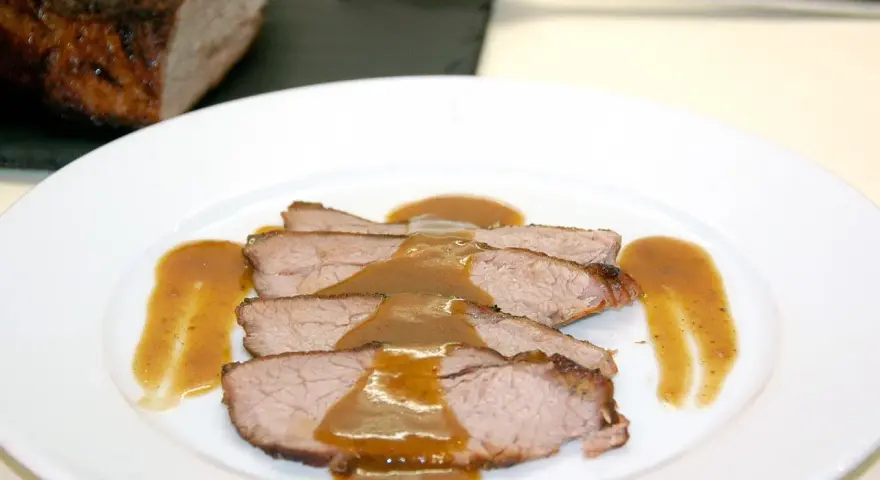 Rabillo de cadera al horno, jugoso y tierno, servido en rodajas con una rica salsa.