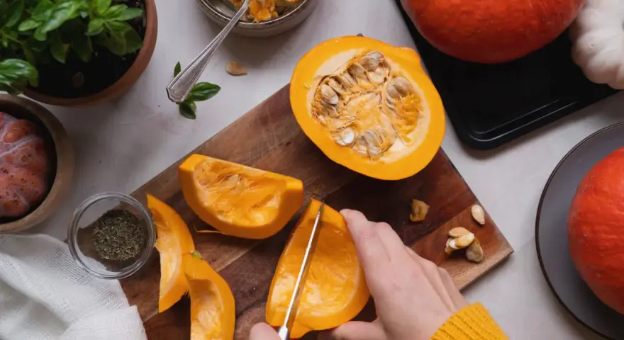 Manos cortando calabaza para deliciosas recetas. Ingredientes frescos listos para cocinar.