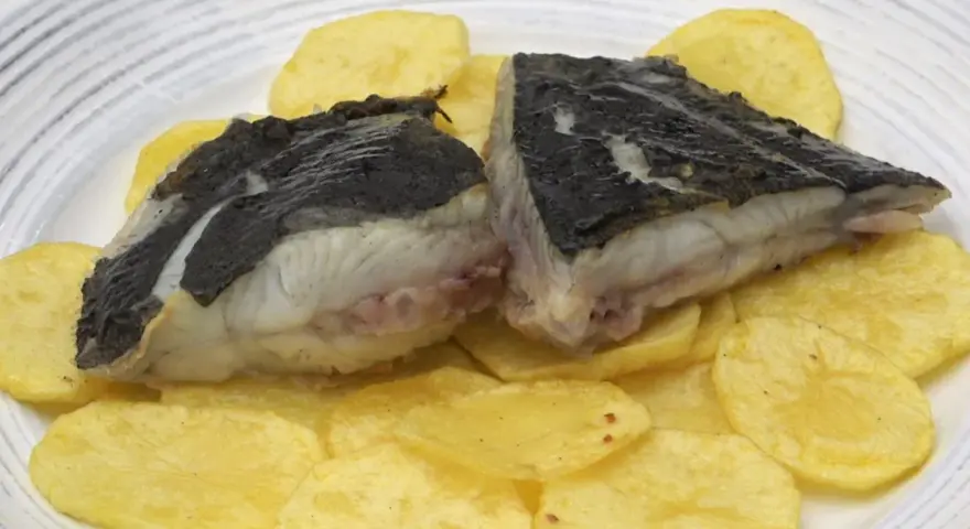 Rodaballo a la plancha, jugoso y tierno, servido sobre patatas fritas crujientes. Un plato sencillo pero delicioso.