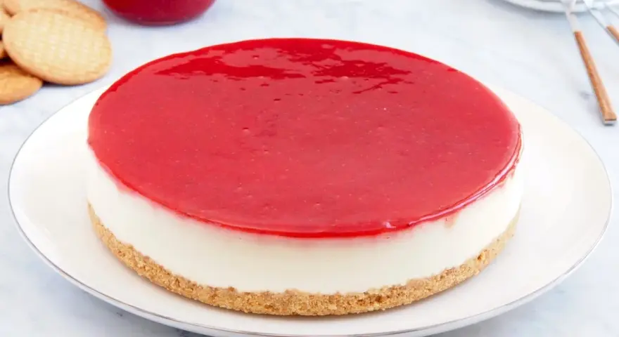 Deliciosa tarta de queso Philadelphia con cobertura roja brillante, lista para disfrutar.