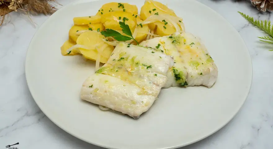 Deliciosa merluza al horno con patatas panadera y perejil picado. Un plato principal ligero y sabroso.