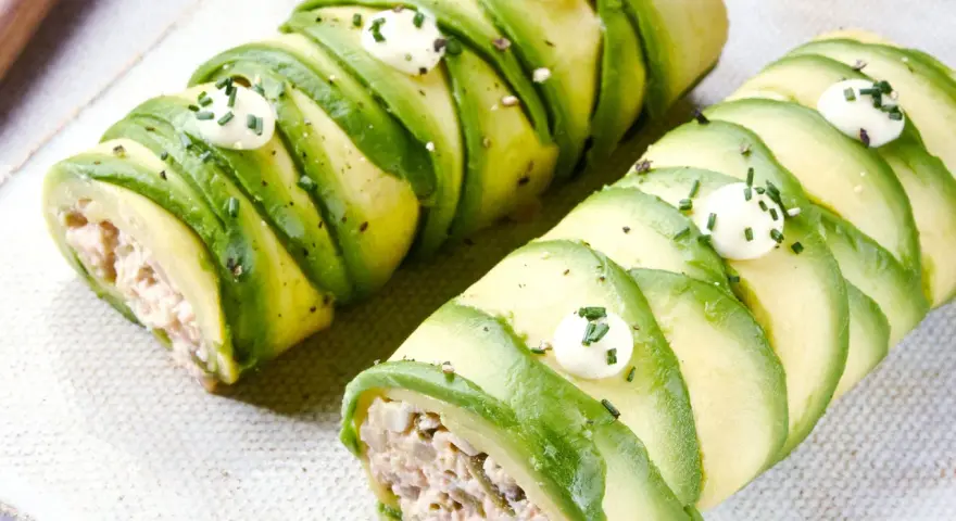 Rollos de aguacate rellenos, perfectos para recetas con aguacate. Decorados con puntos de crema y cebollino.