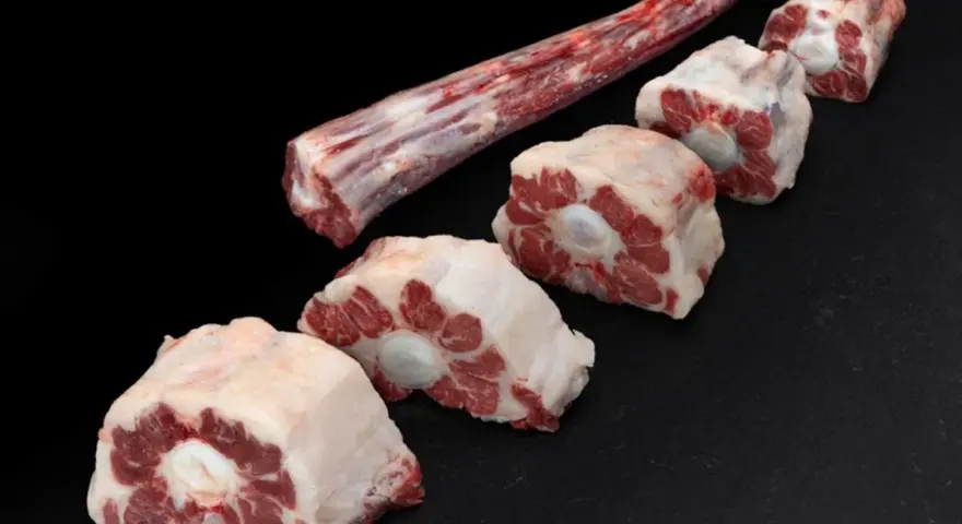 Trozo largo de carne de ternera para guisar y varias porciones cortadas en rodajas, listas para un estofado delicioso.