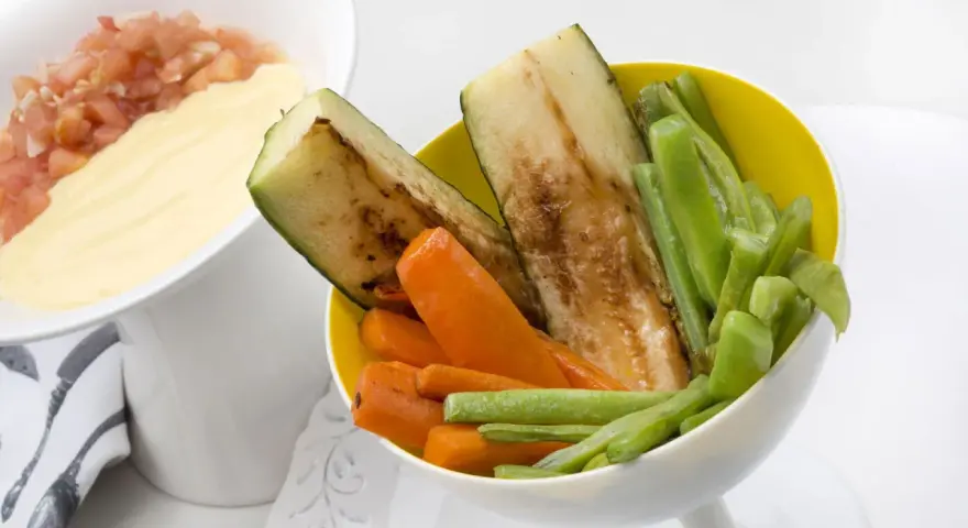 Deliciosas verduras a la plancha: calabacín, zanahoria y judías verdes, servidas con una salsa cremosa y pico de gallo.