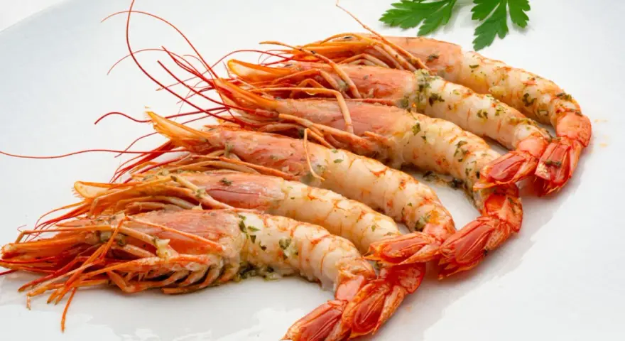 Gambones al horno, jugosos y con un toque de perejil, listos para disfrutar.