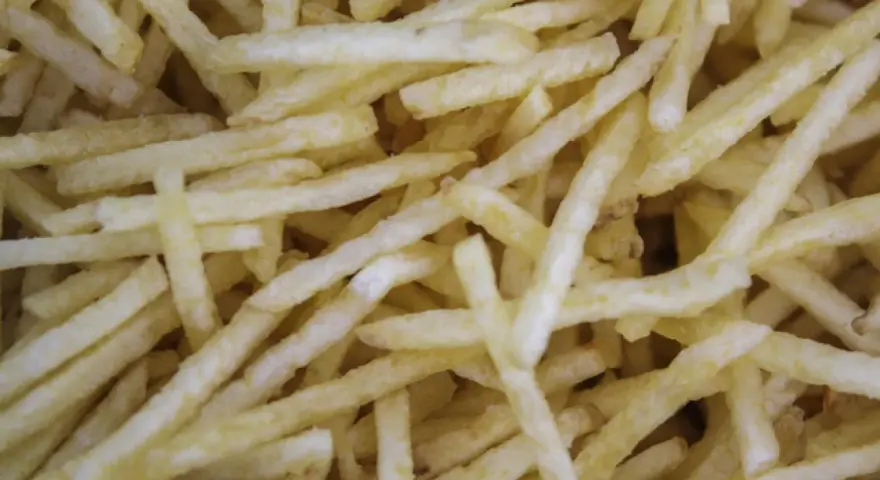 Un montón de patatas paja doradas y crujientes, listas para ser disfrutadas.