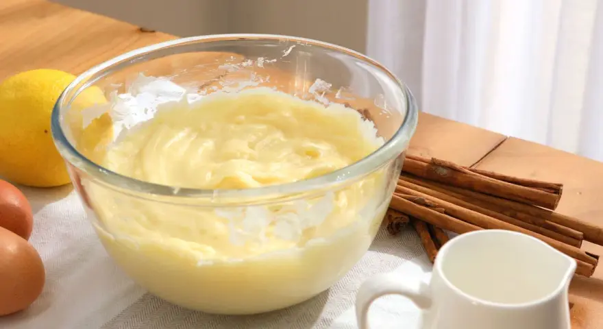 Bol con crema pastelera, huevos, limón y canela. Ingredientes para un postre delicioso.