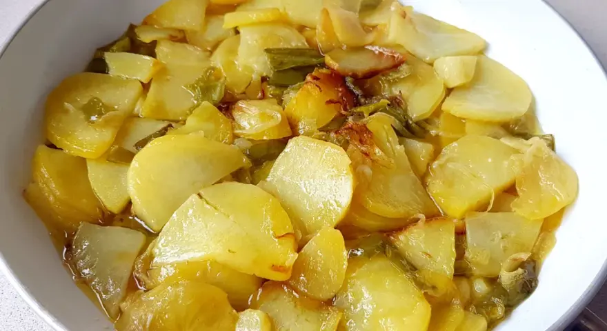 Patatas a lo pobre, un plato sencillo y delicioso, con patatas cortadas finas y tiernas, cocinadas con cebolla y pimientos verdes.