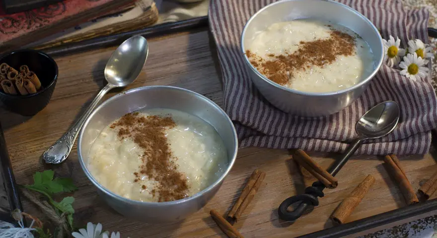 Dos cuencos de cremoso arroz con leche, espolvoreado con canela, listos para disfrutar. Un postre perfecto hecho con Thermomix.