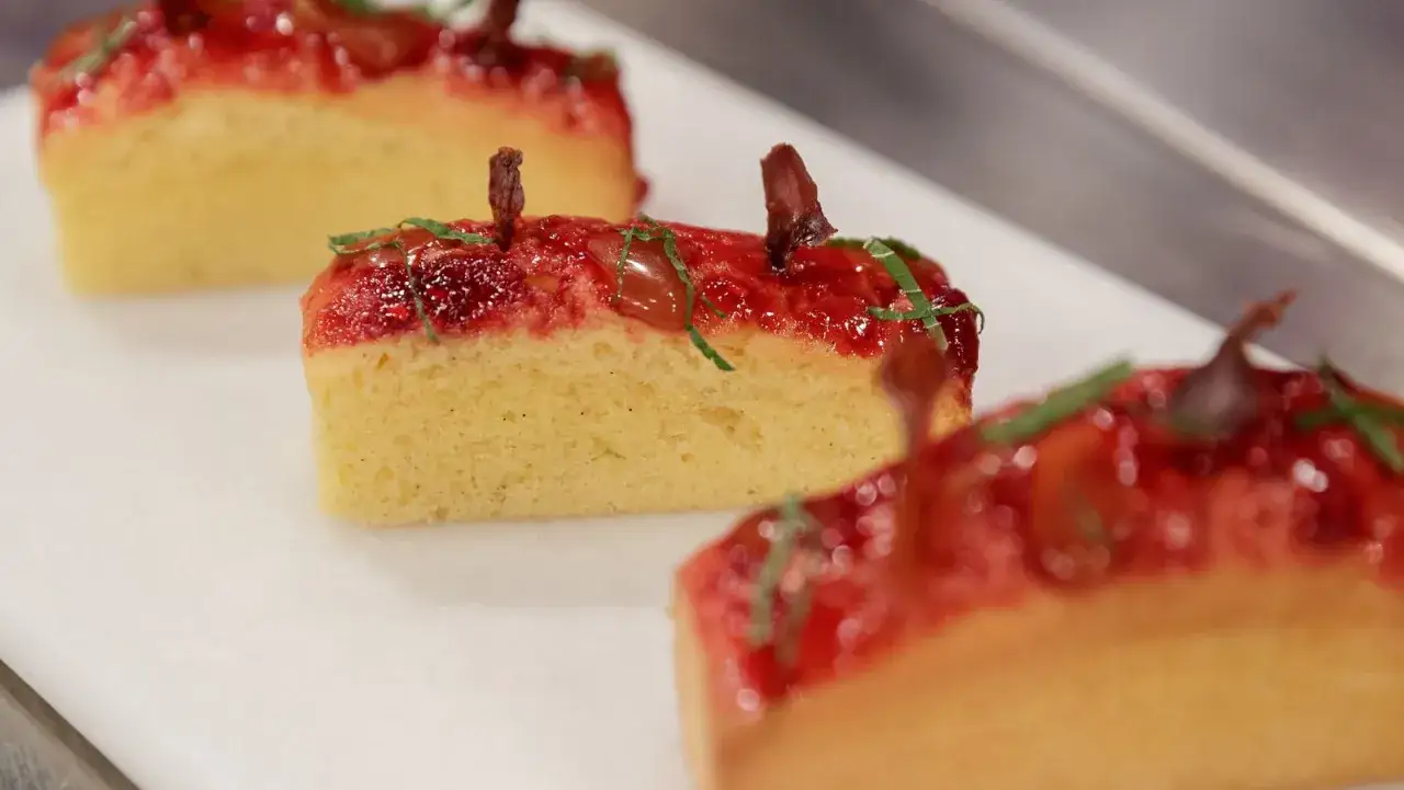 Delicioso pan de calatrava con cobertura de frutos rojos y decoración verde.