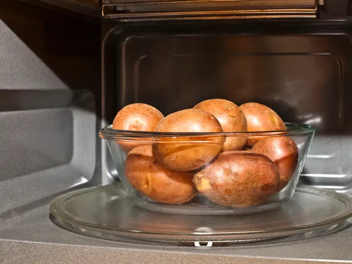 Un tazón de patatas rojas listas para cocinar al microondas.