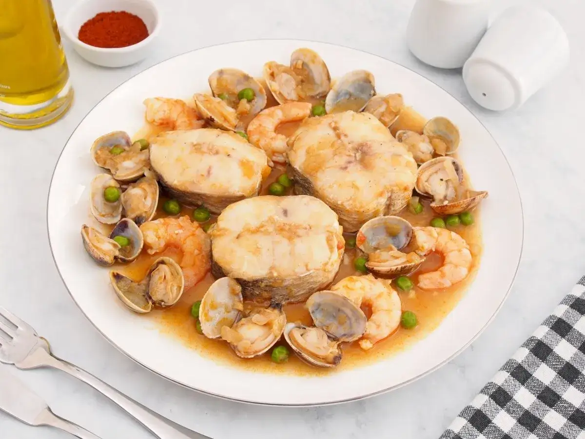 Merluza a la cazuela con gambas y almejas, un plato marinero delicioso.