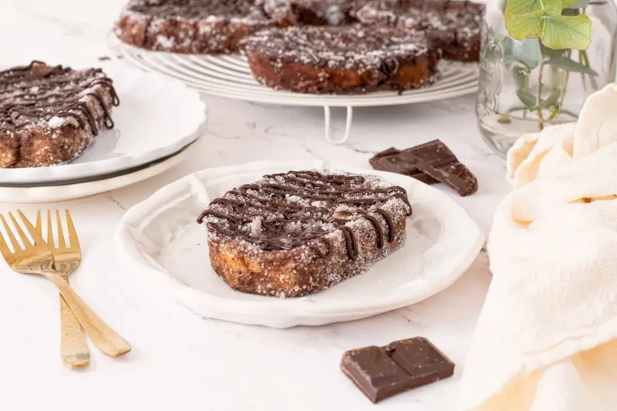 Torrijas de chocolate cubiertas de azúcar y con un glaseado de chocolate, listas para disfrutar.