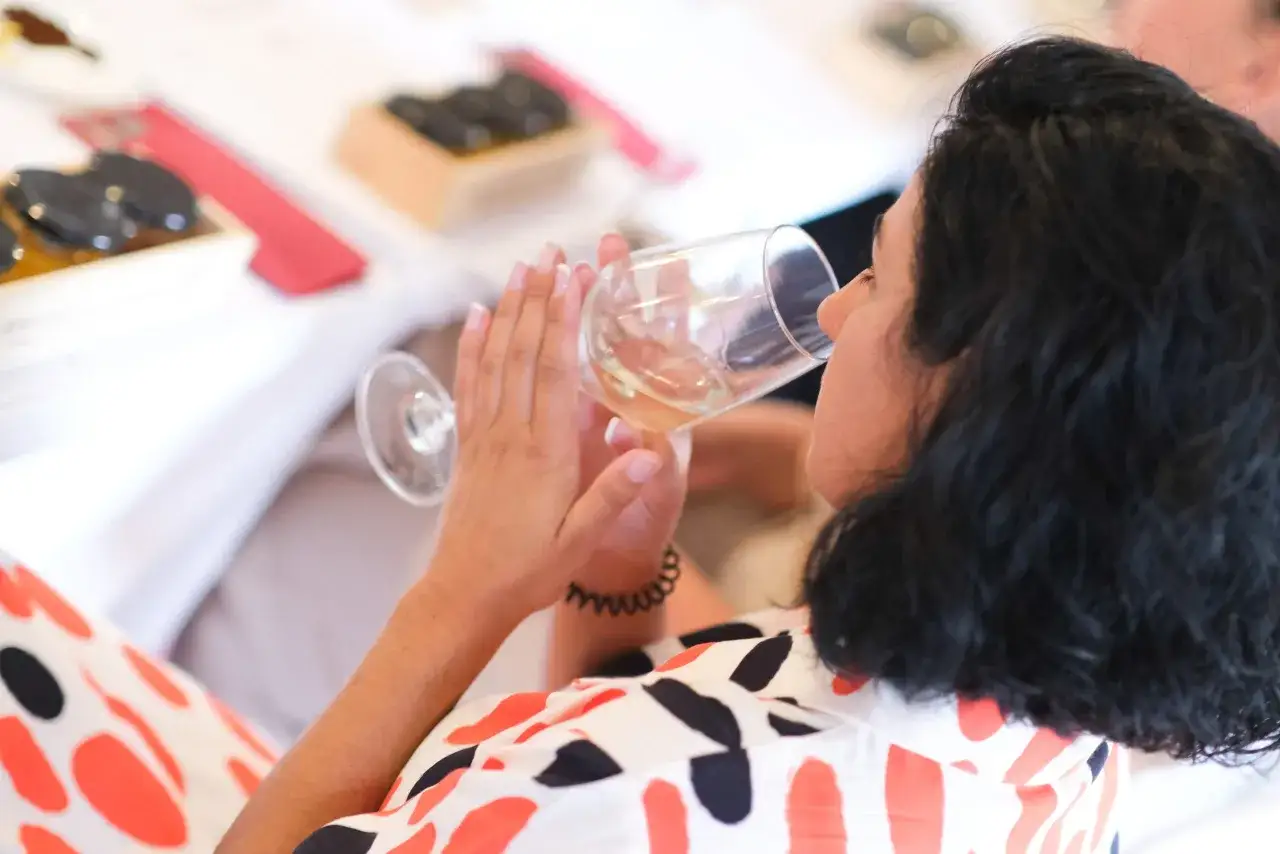 Una catadora de vinos degusta un blanco en una cata.