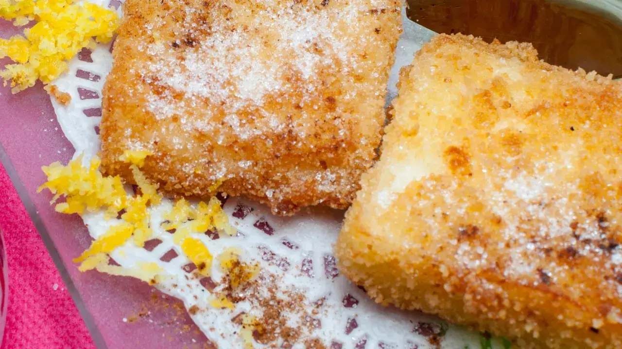 Dos porciones de leche frita, espolvoreadas con azúcar y canela, listas para disfrutar. Una deliciosa receta fácil de preparar.