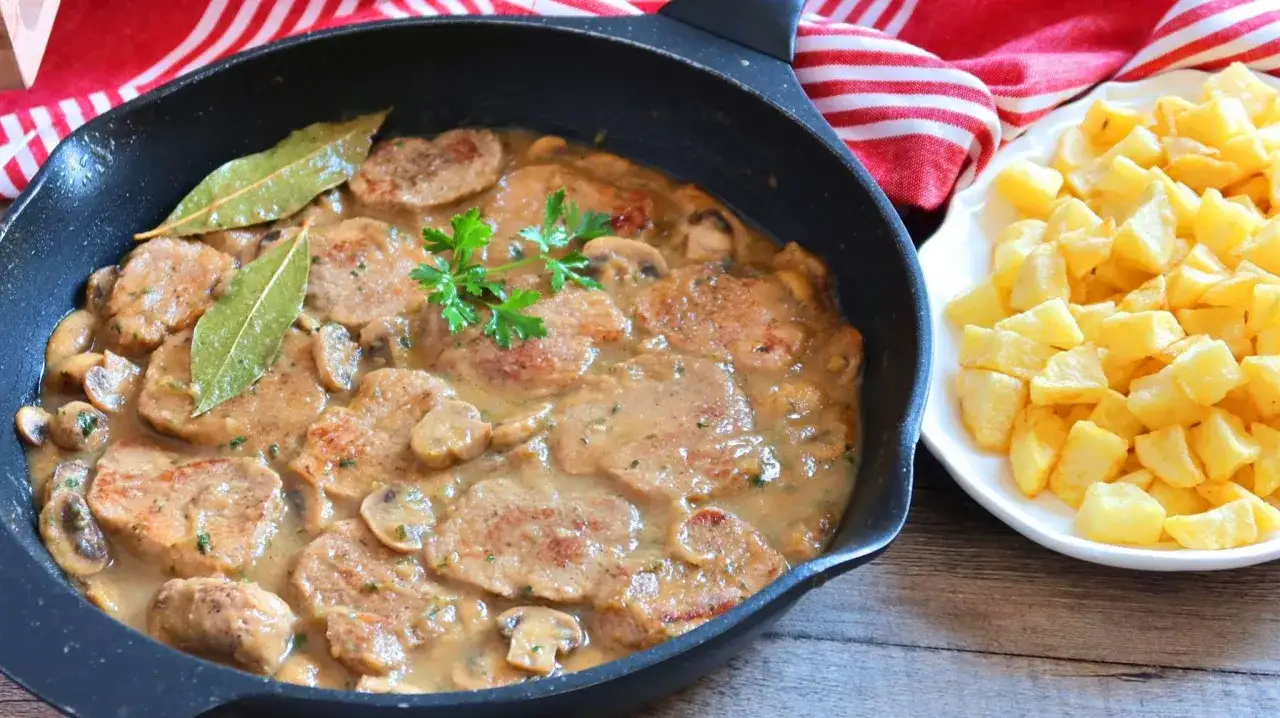 Delicioso solomillo de ternera guisado en salsa cremosa con champiñones, acompañado de patatas fritas crujientes.
