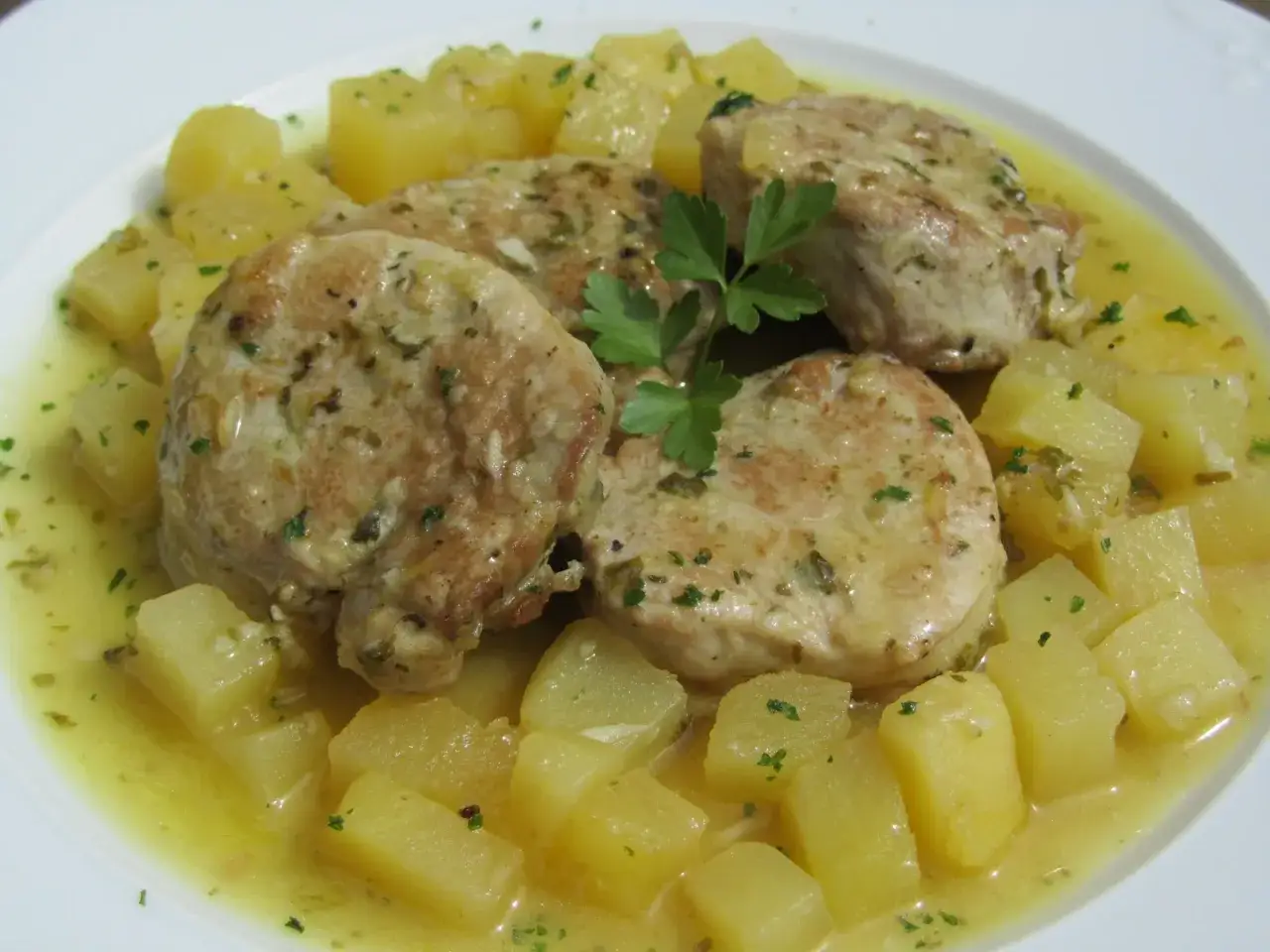 Solomillo al ajillo jugoso con patatas doradas y perejil fresco. Un plato casero que huele a ajo y a hogar.