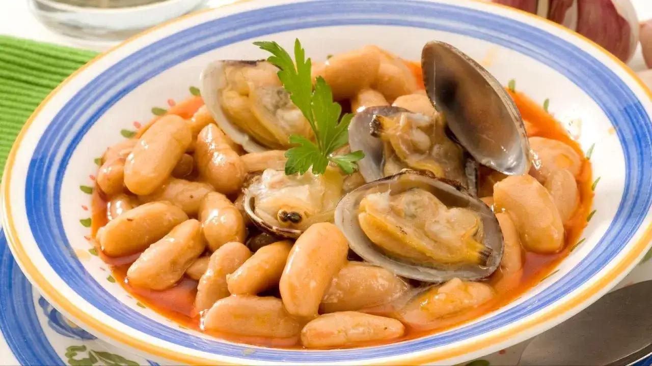 Plato de fabes con almejas, un guiso tradicional asturiano lleno de sabor.