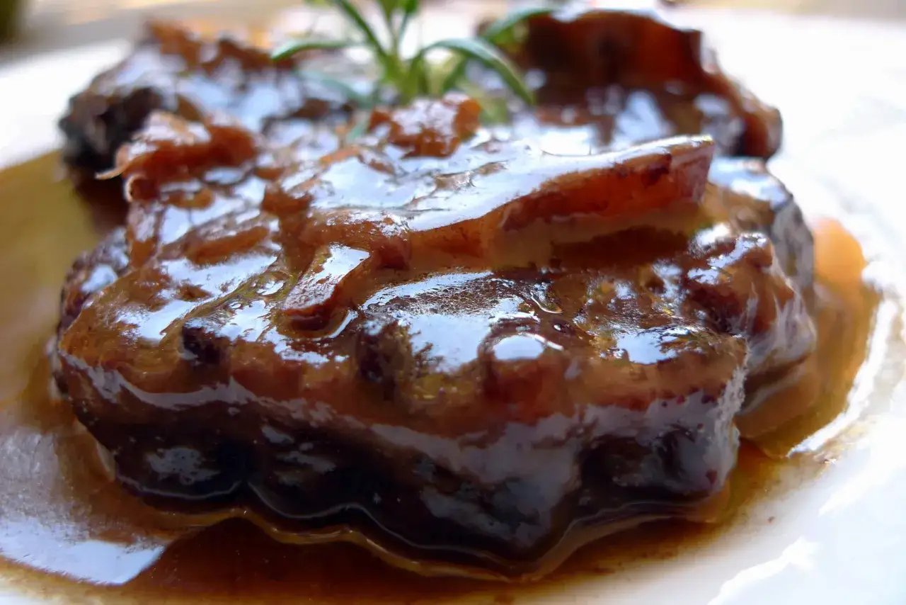 Delicioso plato de cola de toro en salsa, con un toque de romero fresco.