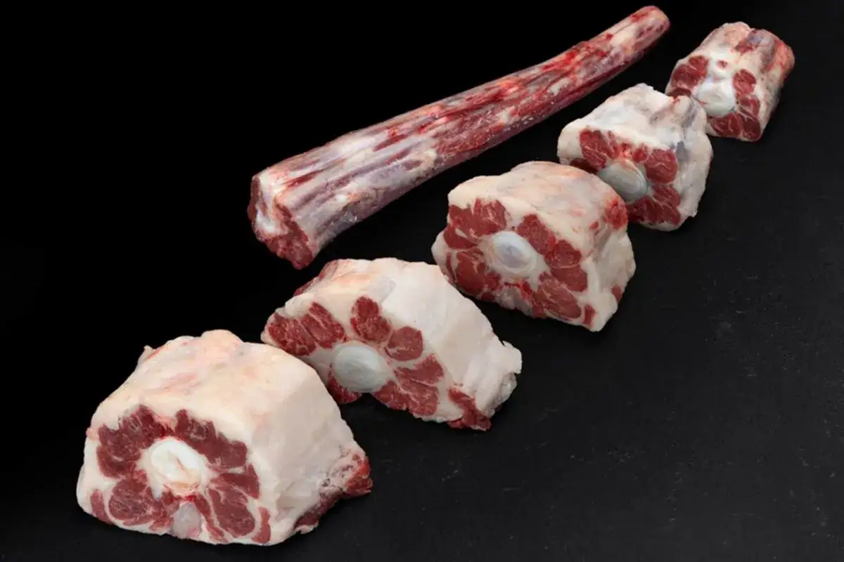 Trozo largo de carne de ternera para guisar y varias porciones cortadas en rodajas, listas para un estofado delicioso.