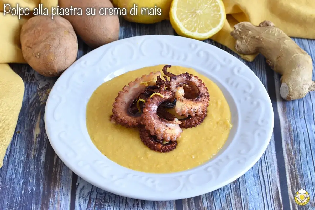 Pulpo a la plancha sobre crema de maíz, adornado con ralladura de limón. Ingredientes frescos como patatas y jengibre acompañan el plato.
