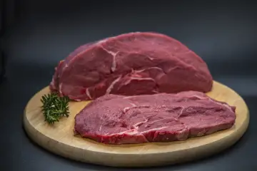 Dos filetes de ternera cruda, uno más grueso y otro más fino, sobre una tabla de madera. ¿Qué filetes de ternera son más tiernos?