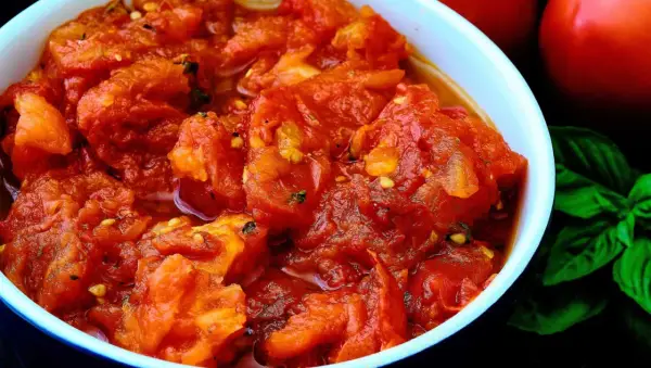 Un tazón de tomates picados, con un toque de albahaca y un aroma delicioso. Un bonito con tomate listo para disfrutar.