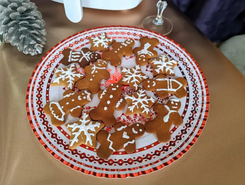 Plato con galletas de jengibre decoradas con glaseado blanco, con formas de hombrecitos, estrellas y copos de nieve. ¡Perfectas para la temporada navideña!